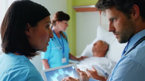 Doctors Reviewing Patient X-ray in Hospital Room