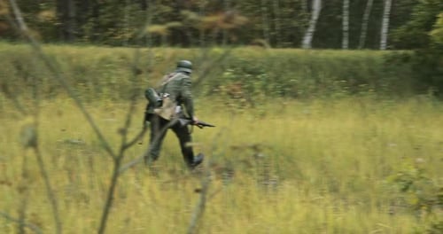 Soldier Running Through Rural Grassy Field with Weapon
