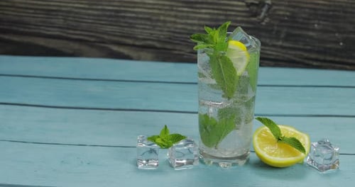 Klares Wasser im Glas mit grünen Minzblättern und Eiswürfeln