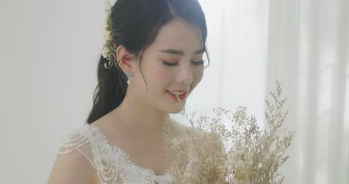 Beautiful Bride Holds Wedding Bouquet and Smiles