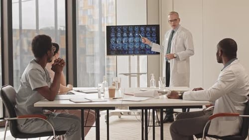Medical Professionals Meeting in Modern Office Presenting Brain Scans