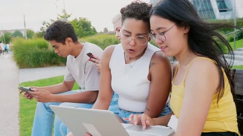 Students Working on Laptop Outdoors on a Bench