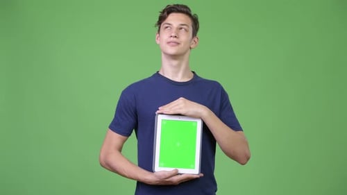 Young Adult Holds Tablet with Green Screen