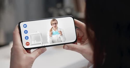 Mujer viendo un Vídeo en un teléfono inteligente sobre la máscara protectora