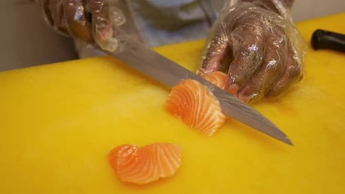 Close-up Chef Cuts Salmon on Cutting Board