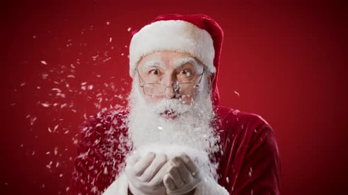 Santa Claus Blowing Snow On Red Background