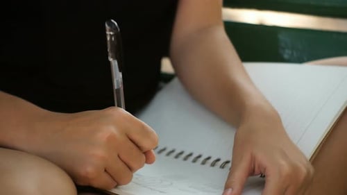 young asian woman writing into her diary in park. Happy hipster young asian woman work on notebook.