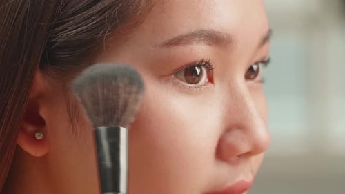 Woman Applying Makeup with Brush in Close Up