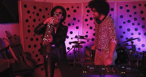 Young people dancing while mixing new album inside boutique recording studio