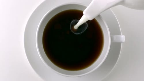 Pouring milk into a cup of coffee, Slow Motion