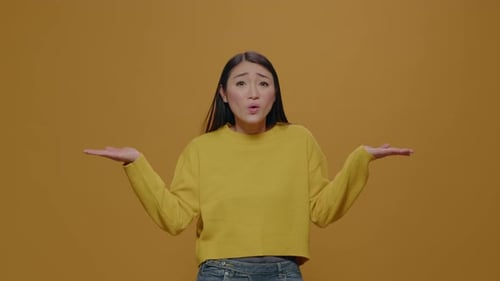 Young Adult Shrugging with Yellow Background