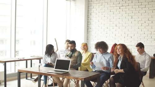 Diverse Team Applauds Presenter in Modern Office