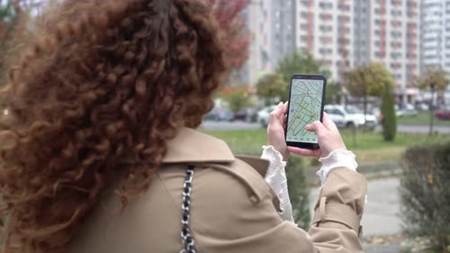 Woman Uses Map on Smartphone in City