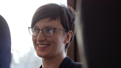 Woman with Glasses Speaks in Office Environment