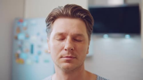 Man Reacts With Shocked Expression in Kitchen