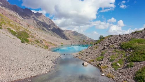 Flying Over a Mountain Lake in Which Clouds are Reflected in Alps Switzerland