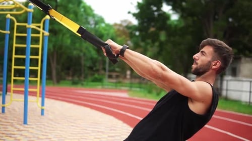 Athletic Man Doing Resistance Band Exercises Outdoors