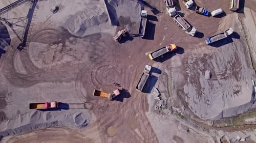 Bagger lädt Schotter in einen Muldenkipper in einem Schottersteinbruch