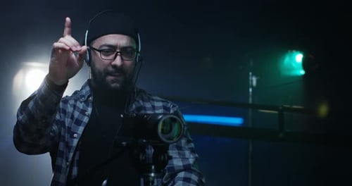 Man Talking in Film Studio With Camera on Tripod