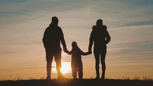 Silhouetted Family Holding Hands at Sunset