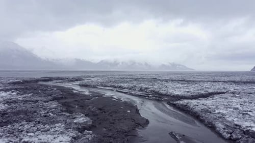 Winding River Through Snowy Mountain Landscape in Winter