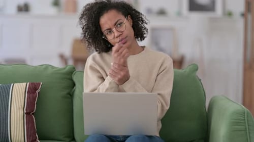 Woman Using Laptop Stretches Sore Wrist at Home
