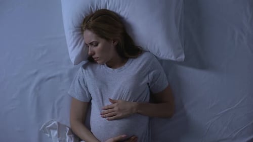Erwartende Frau, die sich nachts ins Bett wirft, Schwangerschaftsschwierigkeiten, Schlaflosigkeit