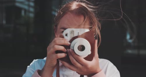 Smiling Woman Taking Photo with Instant Camera