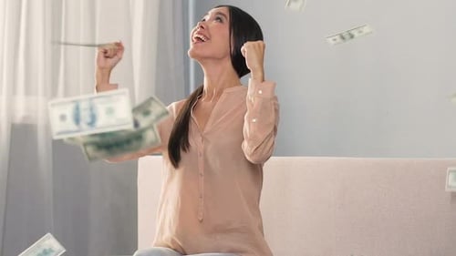 Excited Woman Celebrates with Falling Money Indoors