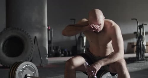 Tired Sportsman Drinking Water After Weightlifting Workout