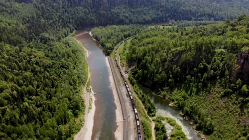 O trem segue ao longo do rio e da floresta