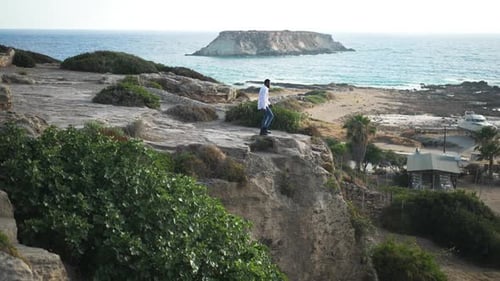 Young Adult on Cliffside Overlooking Ocean