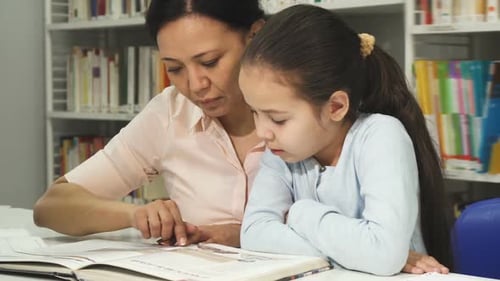 Woman and Child Reading a Book in Library