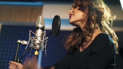 Beautiful young singer who recorded a song in a professional recording studio. Female vocal