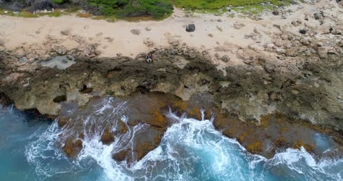 Couple sitting on the rocky sea coast