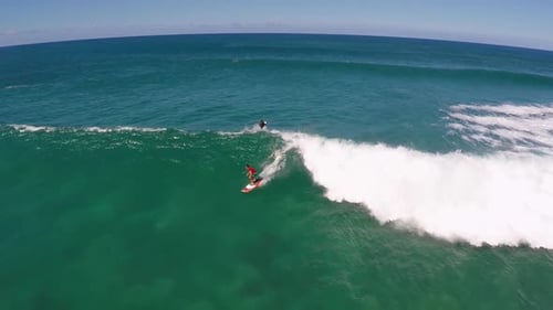Aerial view of a man sup stand-up paddleboard surfing in Hawaii