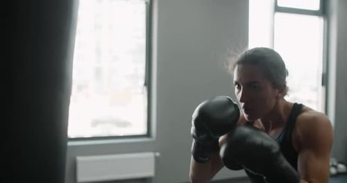 Woman Kickboxer in Boxing Gloves Punches Boxer Bag in Slow Motion Training in Boxing Club 60p Prores