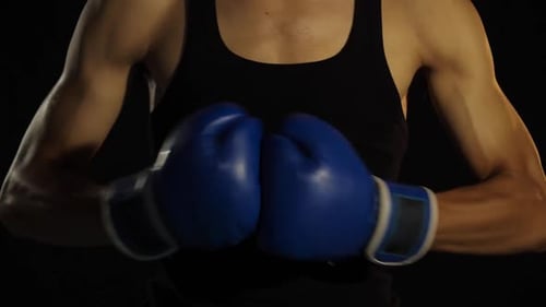 Athlete Putting on Blue Boxing Gloves
