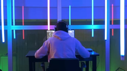 Teen Plays Video Game with Neon Lighting