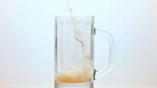 Pale Beer Pouring into Tall Glass Mug