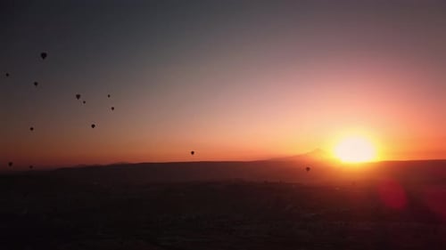Sun is Rising Over Mountain Range and Shining in the Sky Lighting Hot Air Balloons