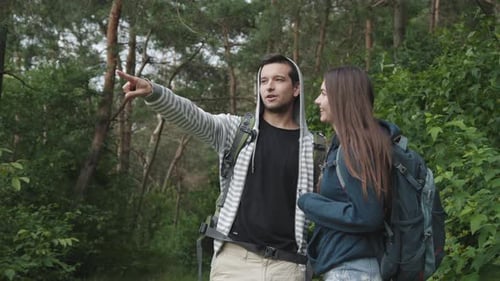 Lovely Couple on the Walk in Forest Having Fun and Looking Into the Distance