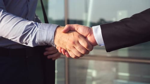 Dolly Shot of Two Businessmen Shaking Hands After Successful Deal Near Office Building. Close Up of