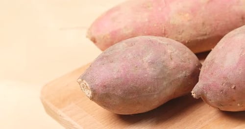 Sweet Potatoes on Wooden Cutting Board Close Up