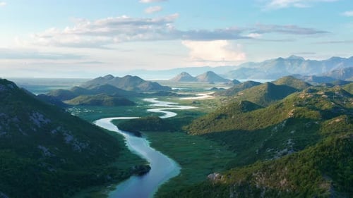 River meandering through the valley toward distant mountains, in the morning