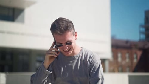 Smiling Man Talking on Phone Outside in City