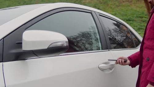 Woman Unlocking Car Alarm Using App in Smartphone