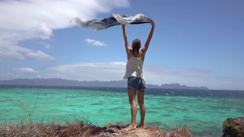 Beautiful Girl on The Sea Windy Beach with Silk Scarf in Hands
