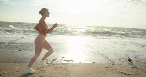 Woman in Sportswear Goes Jogging Along Embankment By Sea