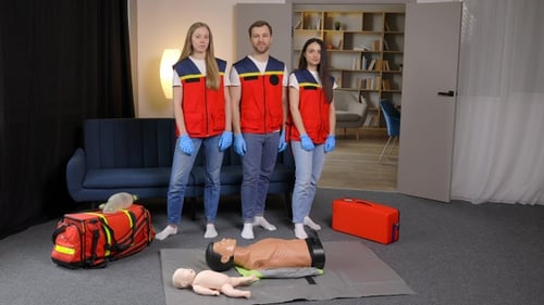Paramedics Standing with Medical Training Dummies